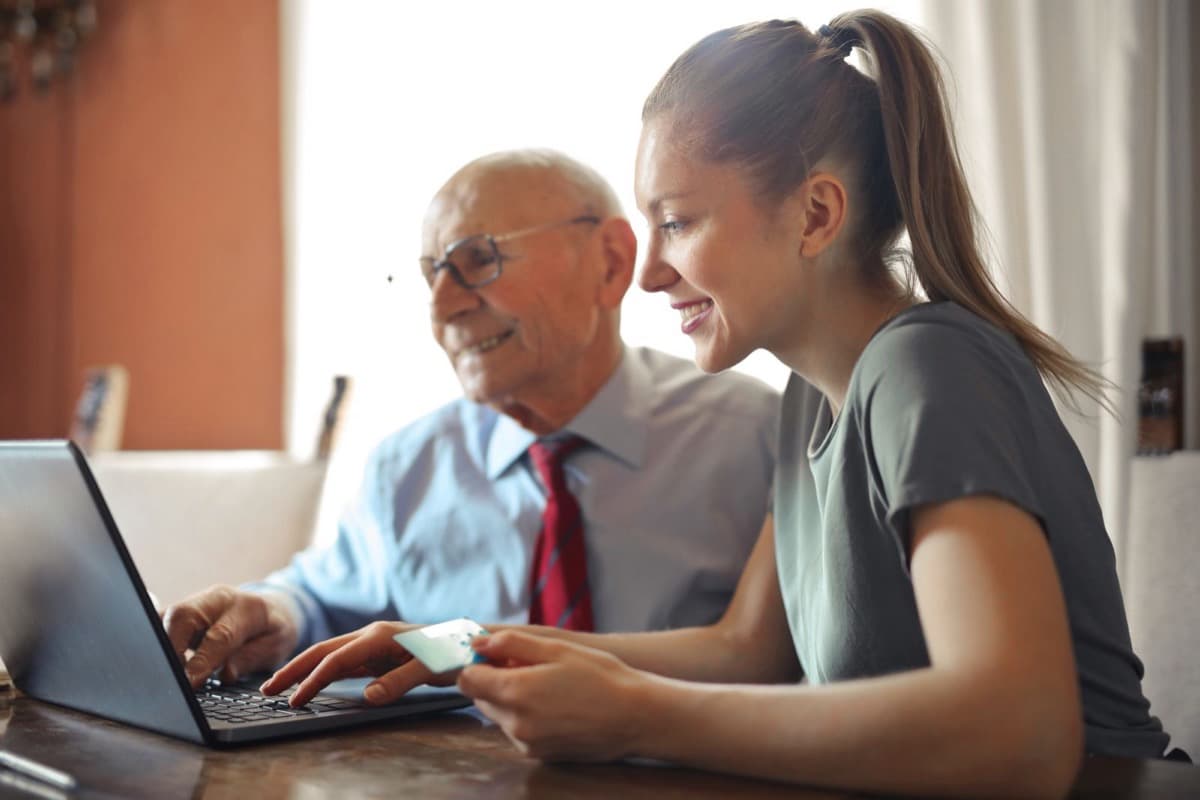 An older man and his daughter reviewing documents together in warm light