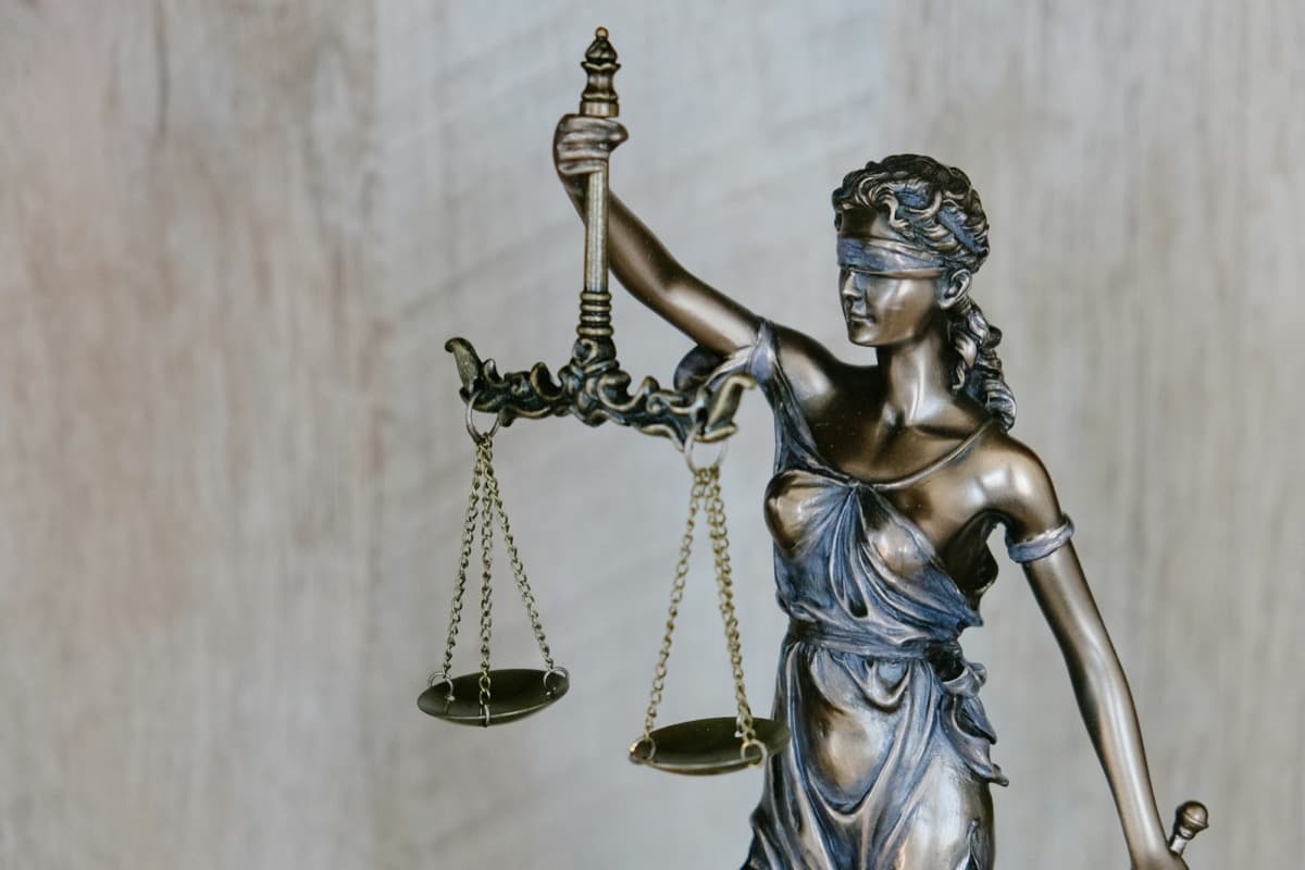 Bronze statue of Lady Justice holding balanced scales