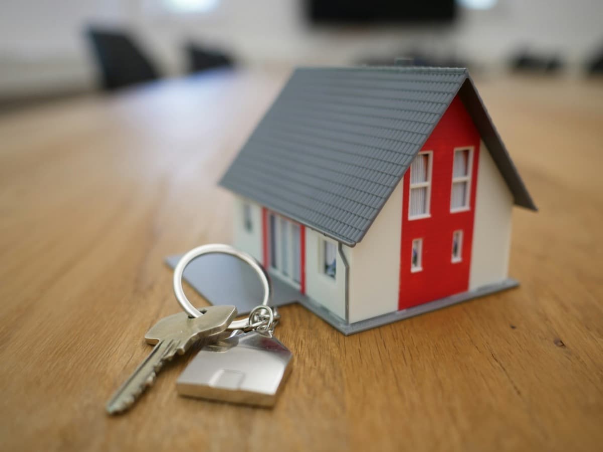 House keys resting beside a model home on a closing table