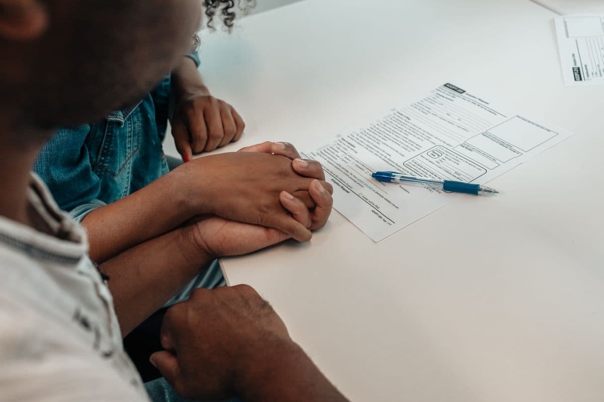 A parent and child completing paperwork together at a table