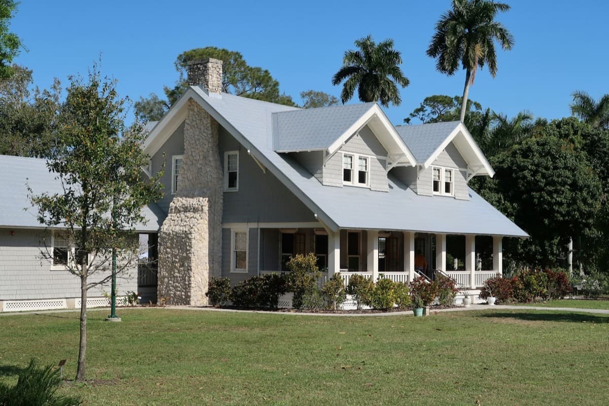 Florida home with a wide front porch framed by tall palm trees